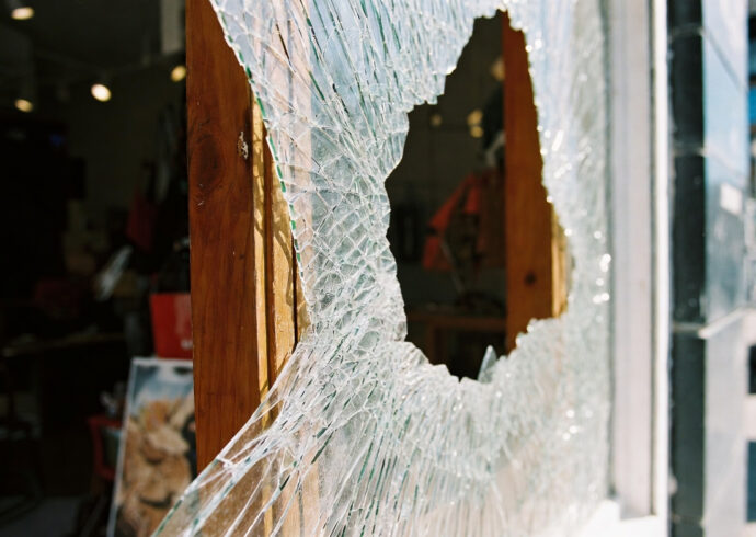Une vitre brisée ou un panneau de bois (placage) posé sur une vitrine/fenêtre.